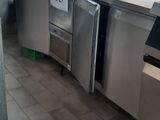 un sol carrelé dans une cuisine professionnelle équipée d'appareils en acier inoxydable et dotée d'une grande fenêtre