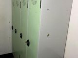 trois casiers dans une pièce où est accrochée une affiche au mur