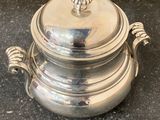 a silver pot with a lid sitting on a table