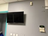 une télévision à écran plat fixée au mur au-dessus d'un lavabo