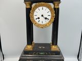une horloge noire et or posée sur une table