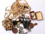 un tas de bijoux en or et en argent posés sur une surface blanche