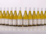 six bouteilles de vin blanc alignées sur une table
