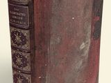 an old book sitting on top of a table next to a white wall