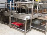 une cuisine avec de nombreuses étagères en inox posées au sol