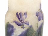a vase with a purple flower on it sitting on a table
