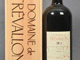 a bottle of red wine next to a wooden box