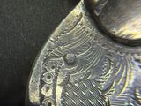 a close up of a silver object on a black surface