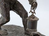 a statue of a monkey holding a bell on a rock