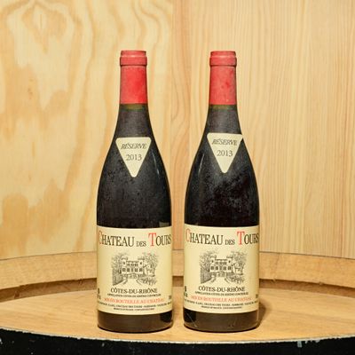 two bottles of wine sitting on top of a barrel