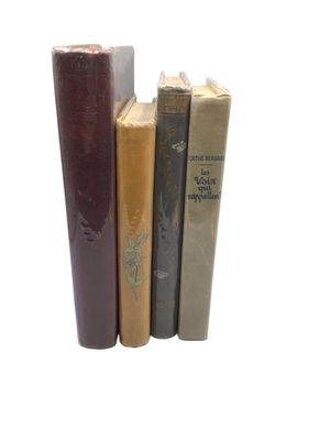 several books are stacked on top of each other on a white surface