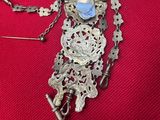 a silver necklace with a blue stone on it