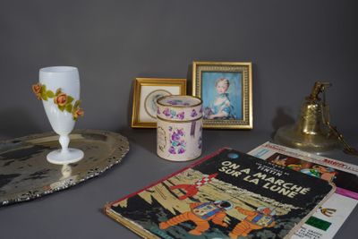 une table sur laquelle se trouvent un vase, un livre et des photos