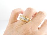 a person ' s hand holding a ring with a baguet