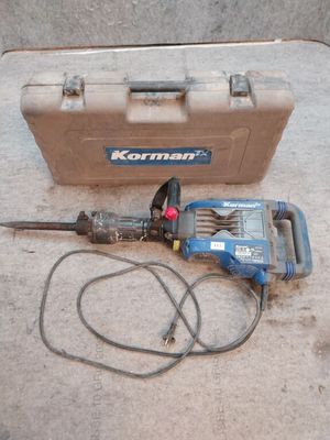 un marteau posé par terre à côté d'une boîte à outils