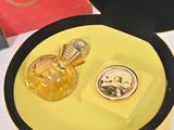 a yellow box with a perfume bottle and a watch in it