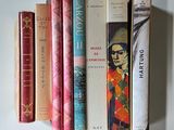 several books are lined up on a shelf on a white surface