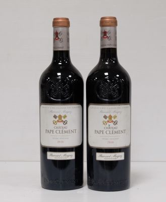 two bottles of red wine sitting next to each other on a table