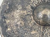 a metal plate with a design on it on a table