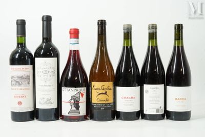 plusieurs bouteilles de vin sont alignées sur une surface blanche