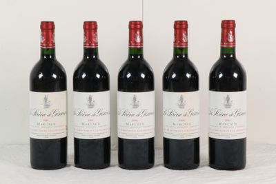quatre bouteilles de vin rouge sont alignées sur une surface blanche
