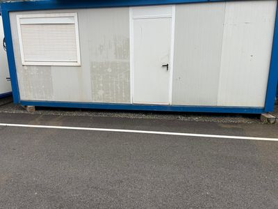 un petit bâtiment bleu et blanc au bord de la route