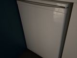 une photo d'un petit réfrigérateur blanc dans une cuisine