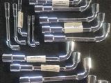 un lot de six raccords de tuyauterie en acier inoxydable posés sur un fond noir