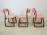 three pink chairs sitting next to each other in a room