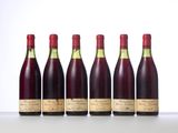 six bottles of wine lined up in a row on a table
