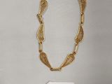 gros plan d'un collier en or sur fond blanc