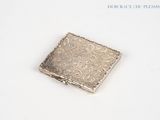 a small square silver object on a white surface