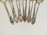 five spoons that are sitting next to each other on a table