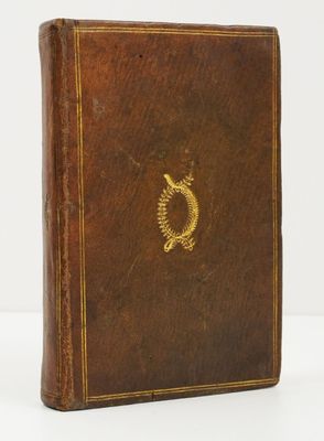 un vieux livre en cuir marron orné d'un emblème doré sur la couverture