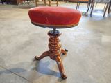 un tabouret rouge posé sur un socle en bois