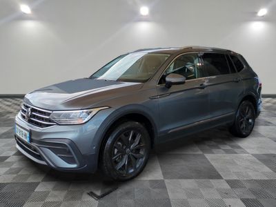 un SUV Volkswagen gris garé dans un garage au sol carrelé