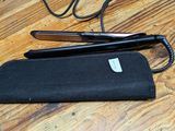 a pair of scissors and a black case on a wooden table
