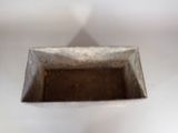 a small metal box with dirt inside of it