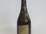 an empty bottle of wine sitting on a white surface