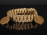 un gros plan d'un bracelet en or orné de deux pièces