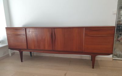 a wooden sideboard with two drawers and a mirror on the wall