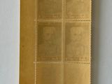 a close up of a piece of gold paper with a picture of a man on it