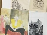 une photo d'un homme assis devant une pile de dessins