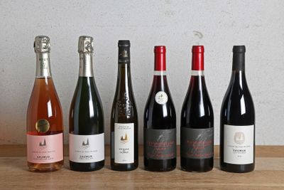 plusieurs bouteilles de vin sont alignées sur une table en bois