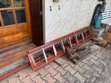 a red bench sitting outside of a house next to a door