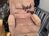 un fauteuil inclinable marron posé au milieu d'une pile de cartons