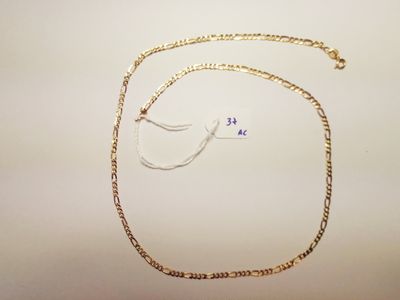 a close up of a gold chain with a small bird on it