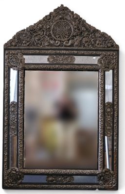 un miroir accroché au mur dans lequel se reflète une personne