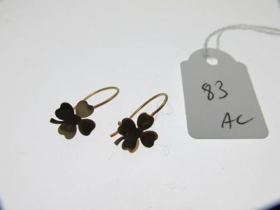 une paire de boucles d'oreilles avec une étiquette de prix posée sur un fond blanc