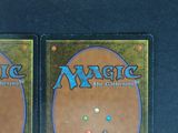 pair of magic the gathering trading cards on a black surface